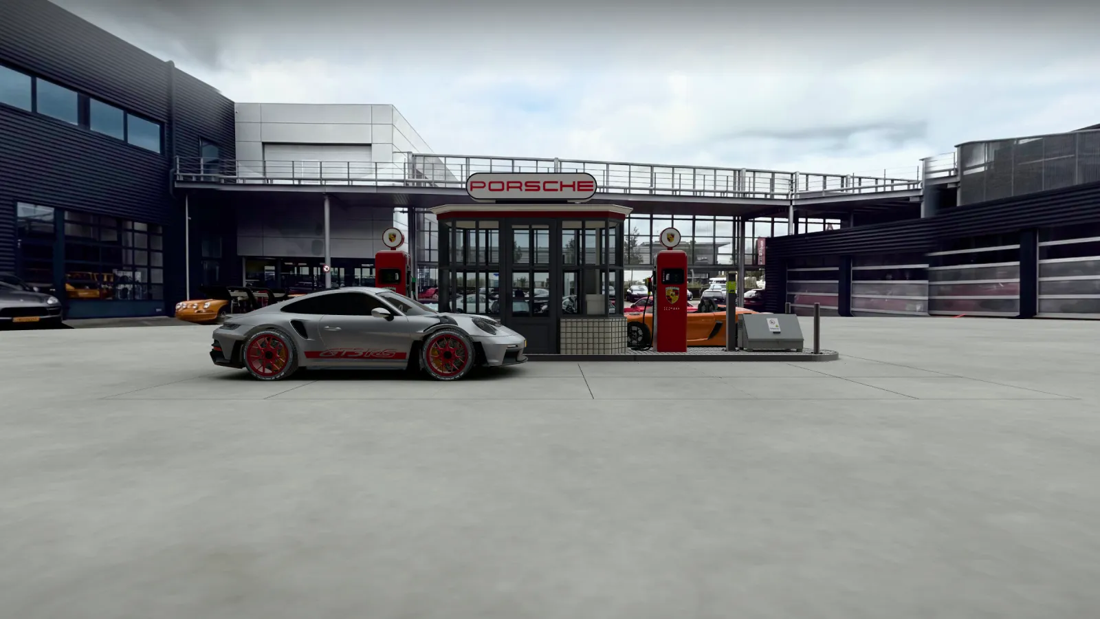 Het pompeiland op schaal 1:18 vanaf de binnenplaats: kiosk met PORSCHE-lichtbak, twee rode pompen, een zilveren 911 GT3 RS en een 718 Spyder RS