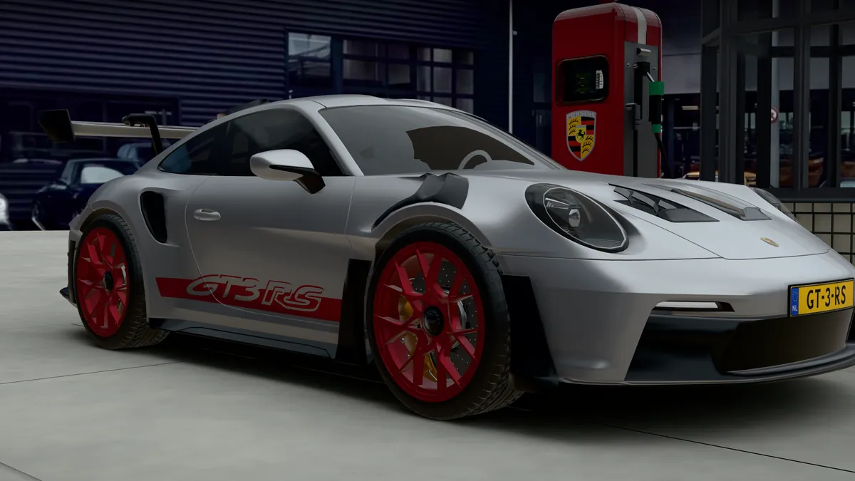 The silver 911 GT3 RS with red wheels and GT3 RS lettering, seen from the front quarter